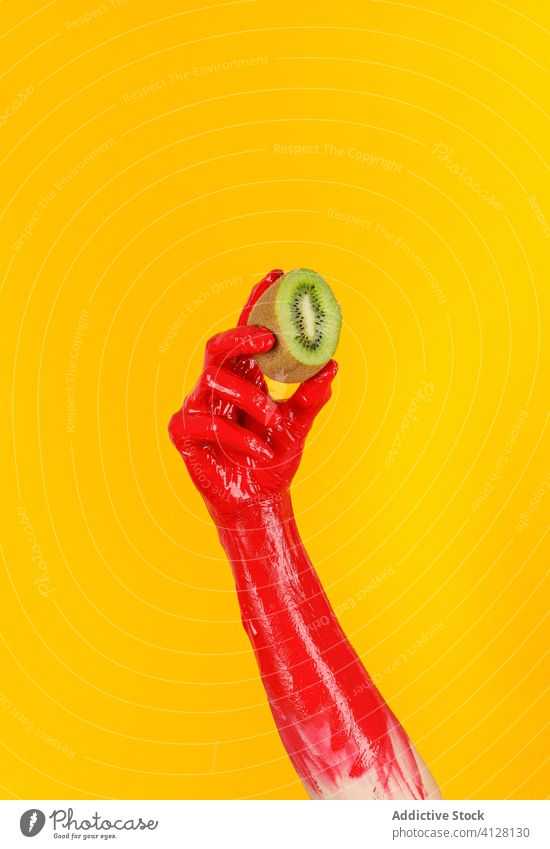 Crop Person mit bemalter Hand und frischer Kiwi Farbe reif Frucht kreativ geschmackvoll abstrakt Kunst Konzept pulsierend farbenfroh hell lebhaft Vitamin