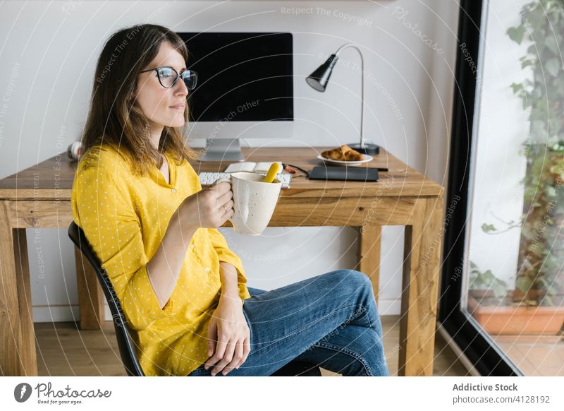 Nachdenkliche Frau trinkt Kaffee und schaut aus dem Fenster nachdenklich ruhen Telearbeit Pause Getränk Computer freiberuflich trinken sich[Akk] entspannen