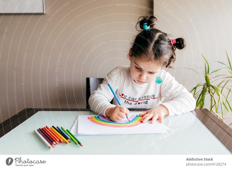 Mädchen zeichnet Bild auf Papier am Tisch zu Hause Zeichnung Regenbogen Bleistift kreativ Optimist positiv farbenfroh hell Inspiration Kind Kunst Farbe zeichnen