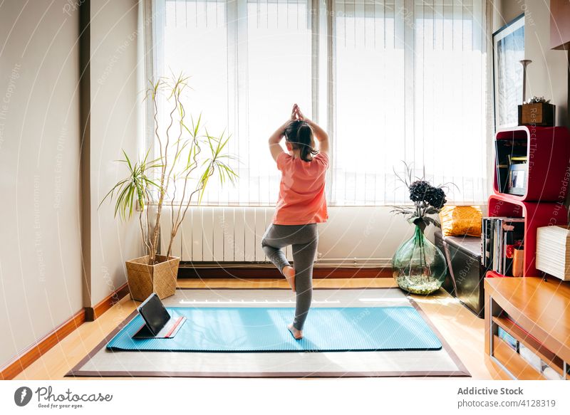 Kleines Mädchen übt Yoga in Baumhaltung Kind Asana üben heimwärts Tablette online vriksasana beweglich Dehnung wenig Unterlage Gleichgewicht Konzentration Video
