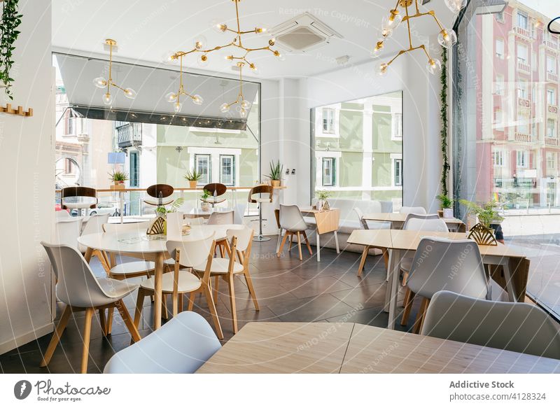 Interieur eines geräumigen modernen hellen Restaurants mit gemütlichen Möbeln und futuristischen Lampen Design Innenbereich trendy Dekor Bar Stil Fenster Stuhl
