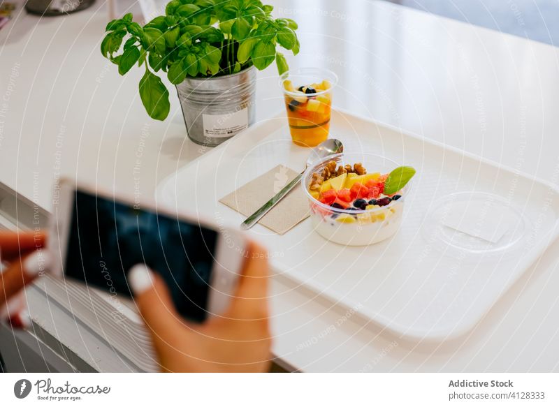 Anonyme Frau fotografiert Dessert auf dem Tisch mit Smartphone Restaurant Frucht fotografieren Mittagessen Food-Fotografie Gesundheit frisch sitzen Speise