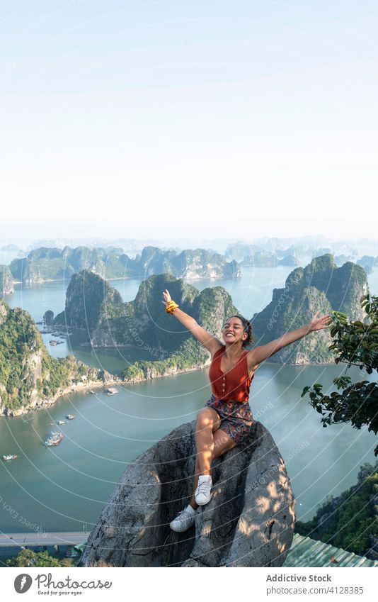 Fröhliche Touristin auf hohem Felsen über der Bucht Halong Bay Aussichtspunkt Frau reisen genießen Sommer Feiertag ha lange Bucht Vietnam Asien spektakulär