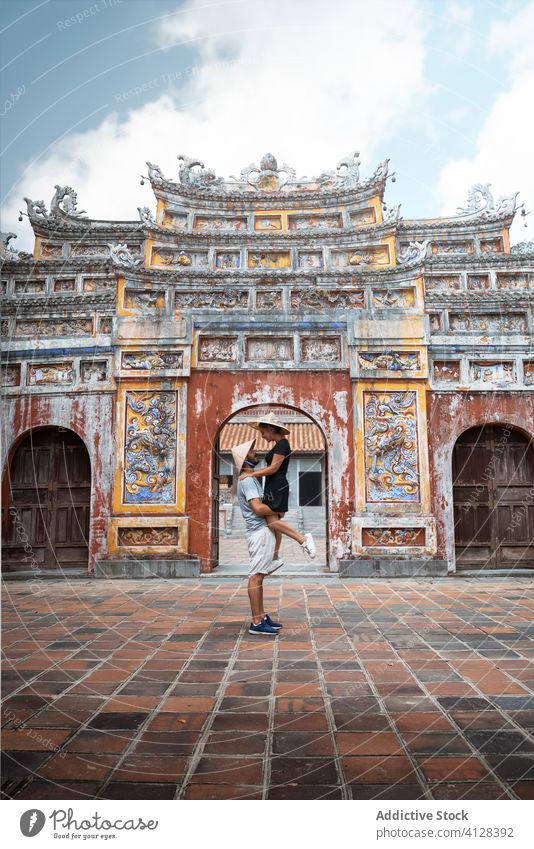 Vergnügtes reisendes Paar in der Nähe des Bogens eines buddhistischen Tempels Buddhismus heben Freund Freundin Urlaub Sommer Vietnam Asien Pagode verliebt