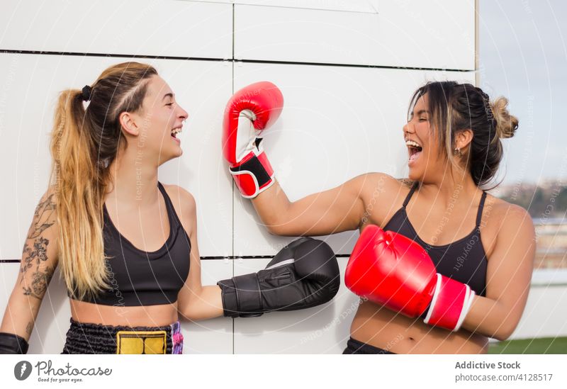 Lächelnde Boxerinnen in Boxhandschuhen nach dem Training Frauen Kämpfer heiter Boxsport Handschuh Inhalt multiethnisch vielfältig rassenübergreifend