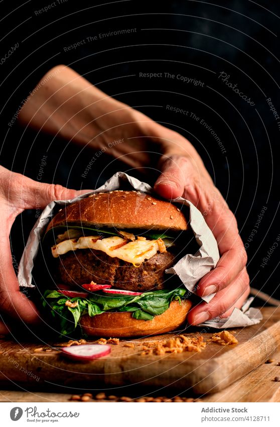 Anonyme Person mit leckerem veganen Linsen-Burger Feinschmecker Hände Veganer Gemüse-Burger Fastfood Essen Halt gebacken natürlich Lifestyle organisch Spinat