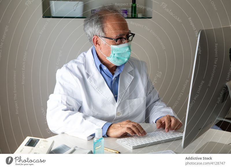 Älterer männlicher Arzt führt telemedizinische Beratung per Laptop in der Klinik durch arzt Telemedizin konsultieren Mann älter Gesundheitstelematik Ausbruch