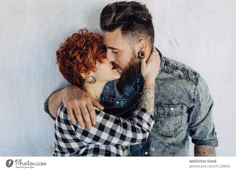 Glückliches junges Paar umarmt fast verwittertes Gebäude Liebe Umarmen Hipster Straße schäbig Zusammensein Umarmung Partnerschaft Tattoo Freund Freundin