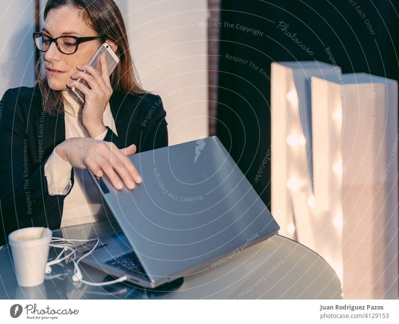 Frau, die ein Telefongespräch führt, während sie einen Laptop-Computer in einer Café-Bar schließt Business Person Dame Talkrunde Anruf Gerät Mädchen Internet