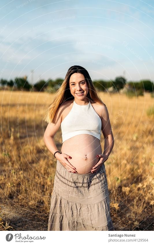 Schwangere Frau Porträt Glück schön jung schwanger Schwangerschaft schwangere Frau Lächeln lieblich Warten Magen berührend Hand Erwachsener Landschaft im Freien