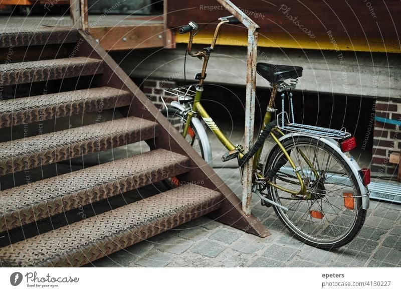 Grünes Fahrrad in einer industriellen Lagerhalle in Hamburg Deutschland Backsteinwand Arbeitsweg dreckig grau industrieller Stil hübsch Verkehr Transport Zyklus