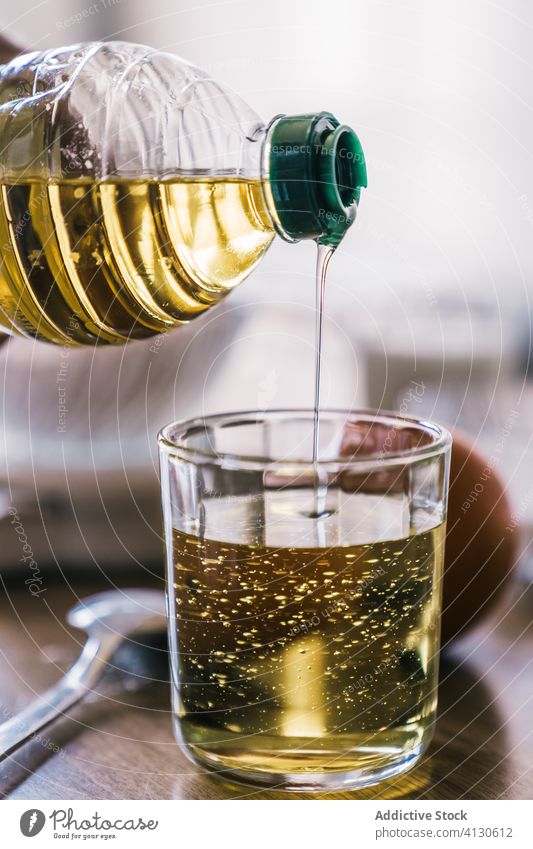 Hausfrau gießt Öl in ein Glas in der Küche Erdöl eingießen Bestandteil Rezept Gebäck messen heimwärts vorbereiten Koch Hand Tisch Lebensmittel selbstgemacht