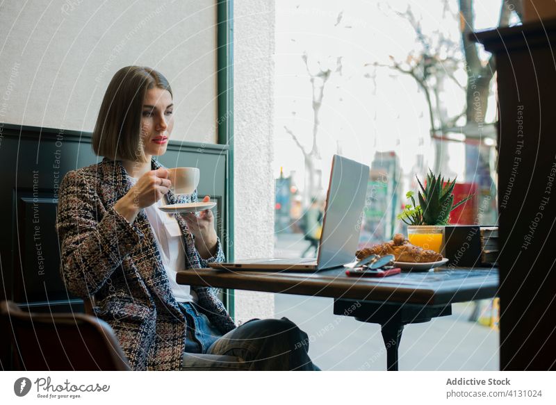 Geschäftsfrau mit Laptop und leerem Bildschirm in einem Café bei Tageslicht leerer Bildschirm Tippen Internet online Tasse Suche benutzend Apparatur Gerät