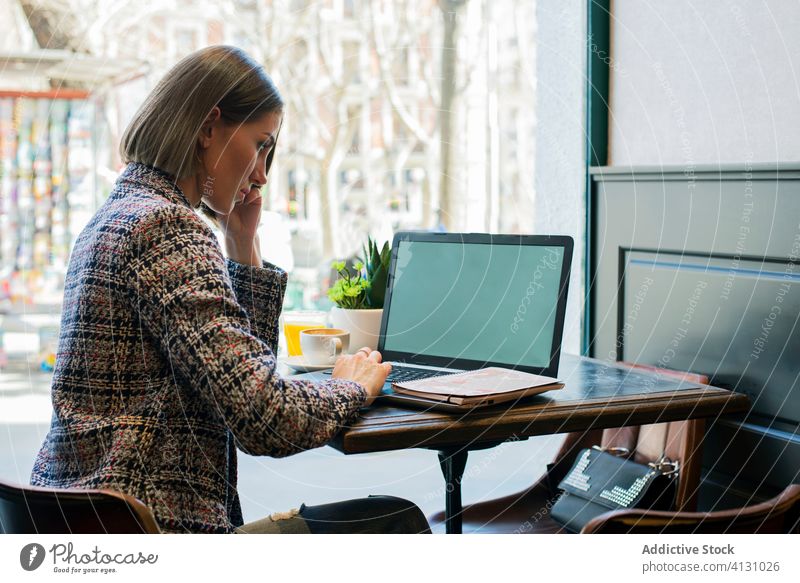 Geschäftsfrau mit Laptop und leerem Bildschirm in einem Café bei Tageslicht leerer Bildschirm Tippen Internet online Tasse Suche benutzend Apparatur Gerät