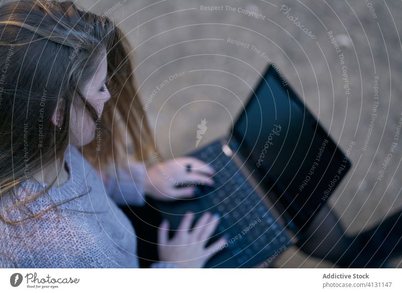 Rückenansicht einer Frau mit Laptop auf einer Holzbank im Park Bank Tippen E-Mail Internet benutzend Gerät Apparatur online sich[Akk] entspannen Anschluss ruhen
