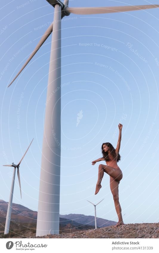 Junge schlanke Dame tanzt an einem sonnigen Tag unter einer Windmühle Frau Body Tanzen Harmonie beweglich Ökologie Natur Umwelt allein hochreichen ausführen