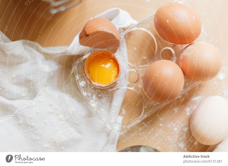 Eier und Mehl auf dem Holztisch zum Kochen von Nudeln Eigelb roh Handtuch Teigwaren vorbereiten Eierschale Tisch Lebensmittel Gastronomie Protein Küche