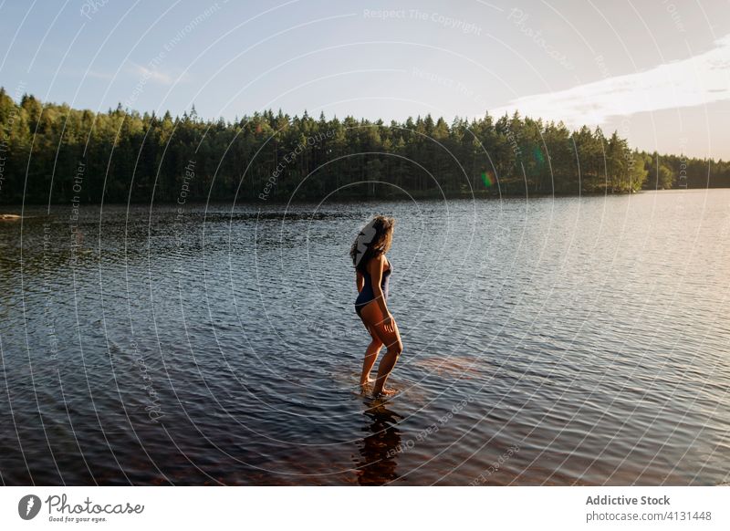 Frau im Badeanzug im See stehend Wasser Windstille Sonnenuntergang genießen Sommer majestätisch Landschaft Wald ruhig Gelassenheit Harmonie friedlich idyllisch