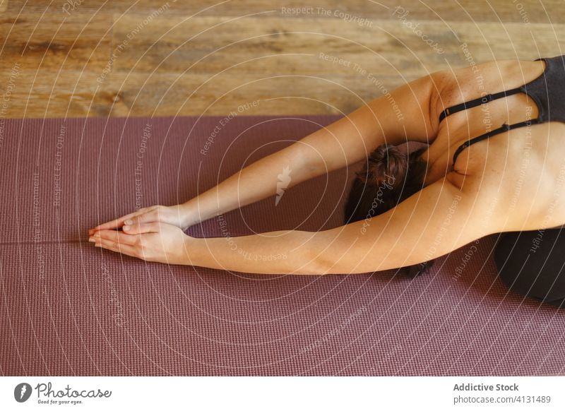 Flexible Frau, die Yoga in der erweiterten Welpenhaltung praktiziert Pose verlängerter Welpe üben Dehnung Übung Unterlage beweglich Windstille Sportkleidung