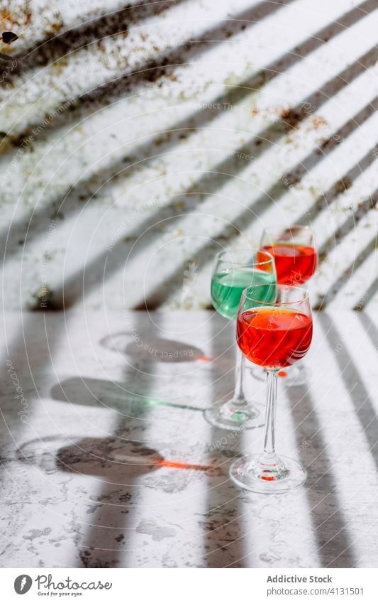 Gläser mit erfrischenden Getränken auf einem schäbigen Tisch in der Nähe einer Pflanze Glas Erfrischung trinken Schatten rostig Cocktail kreativ Design