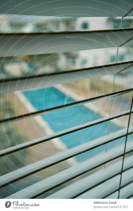 Blick auf das Schwimmbad durch Metalljalousien Fensterjalousien schwimmen Pool Jalousie zu Hause bleiben zugeklappt verboten Lüftungsschlitze Wasser flach Hof