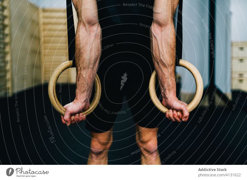 Konzentrierter Sportler beim Turnen an den Ringen gymnastisch Übung Fitnessstudio Training Turner stark Gleichgewicht Athlet männlich Zeitgenosse muskulös