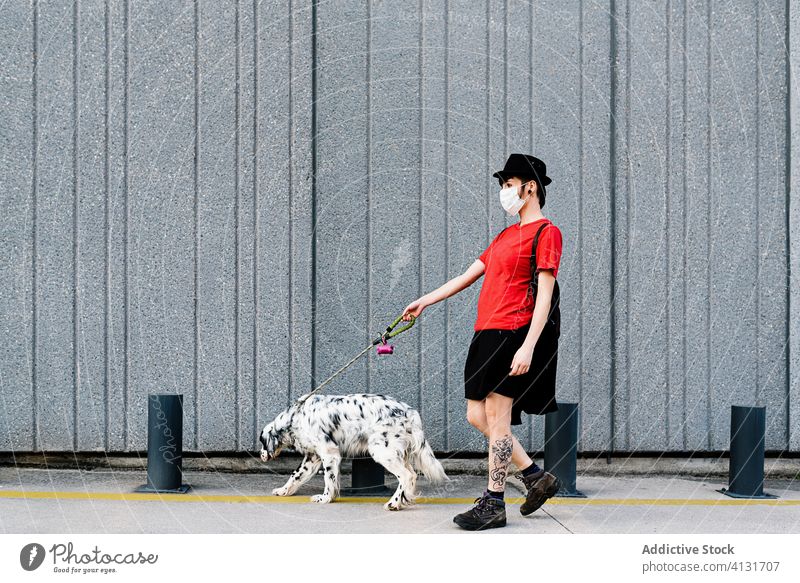 Trendy nachdenklich Frau in Gesichtsmaske zu Fuß mit Hund auf dem Zebrastreifen in der Stadt Besitzer Straße Mundschutz Haustier COVID Überfahrt Tier