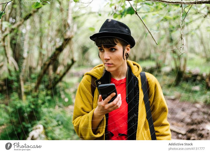 Ruhiger androgyner weiblicher Reisender mit Smartphone im Wald Frau reisen benutzend grün Natur Wälder Funktelefon Asturien Spanien Feiertag Tourist ruhig