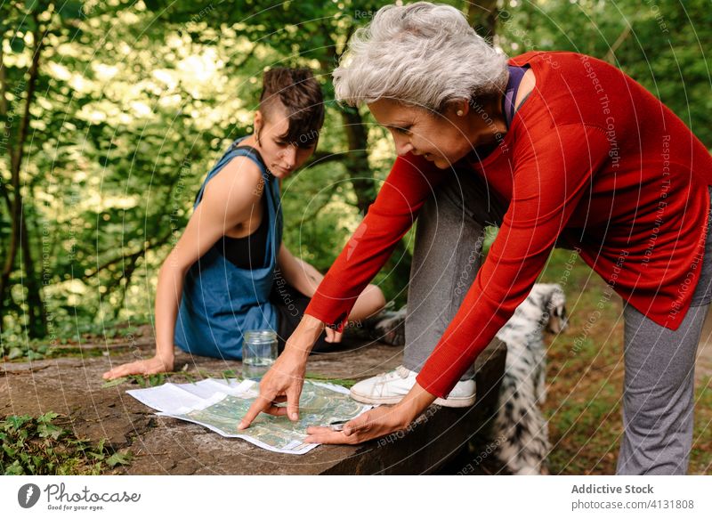 Reisende Frauen wählen die Route mit Karte und Kompass navigieren Wald Landkarte reisen sich orientieren diskutieren Örtlichkeit Senior jung Zusammensein