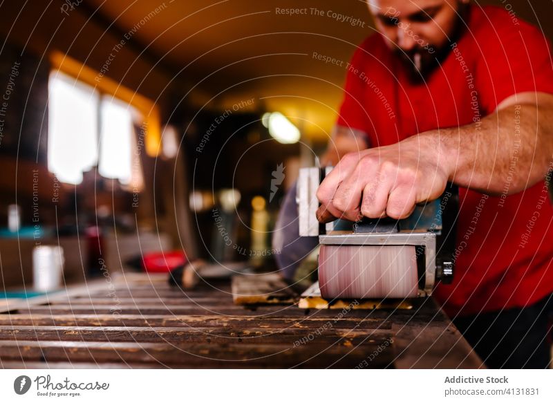 Crop männlich Holzarbeiter mit Bandschleifer Holzarbeiten Schreinerei Bandschleifmaschine Mann Maschine Tischlerin Werkstatt polnisch Prozess Konzentration
