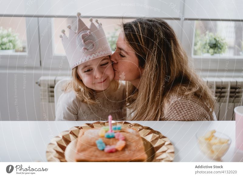 Glückliche Mutter küsst Mädchen mit Geburtstagsparty Bruder feiern Kuss Zusammensein wenig Party aufgeregt heimwärts Kind Tisch positiv Eltern Veranstaltung