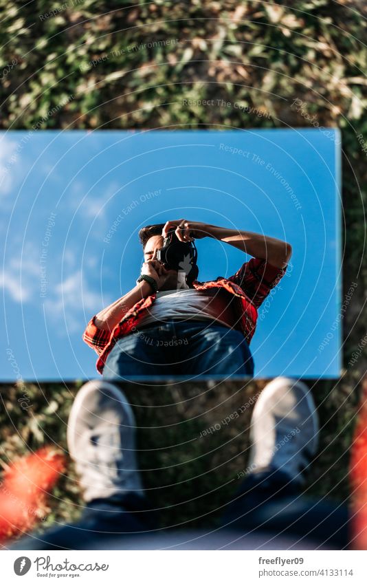 Junger Fotograf nimmt ein Selfie auf jung Mann Spiegel Porträt Selbstportrait Hintergrund abstrakt Himmel Gras Attrappe Textfreiraum Rechteck Wolken Natur Licht