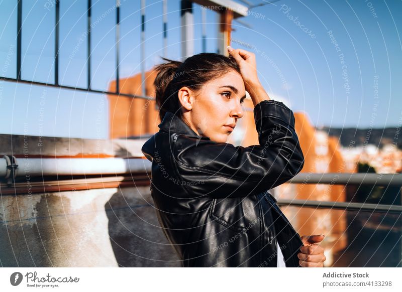 Ruhige stilvolle Frau auf Balkon im Sommer trendy Gelassenheit genießen Sonne Stil Lederjacke Terrasse sonnig Jacke sich[Akk] entspannen ruhen Freude ruhig
