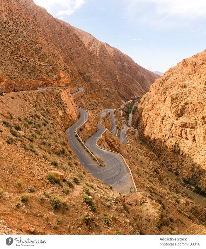 Kurvenreiche Straße in bergigem Gebiet an einem sonnigen Tag Berge u. Gebirge geschlängelt Fahrbahn Felsen Landschaft eng majestätisch rau Marokko Afrika Natur