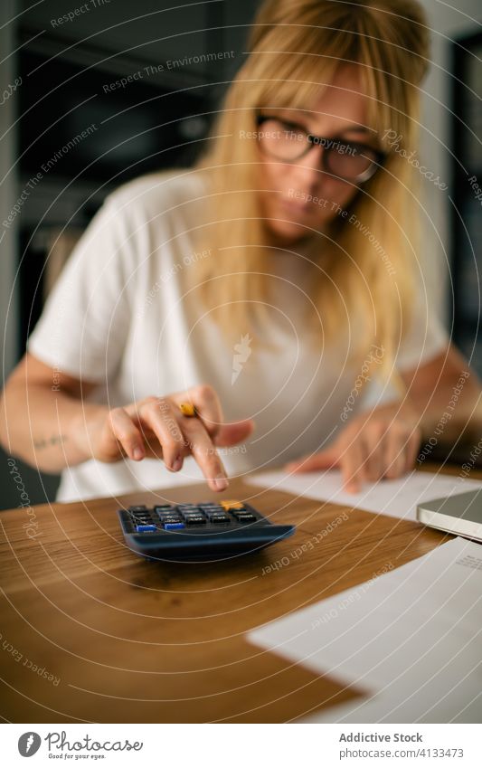 Buchhalterin, die einen Taschenrechner benutzt und aus der Ferne arbeitet Rechner berechnen Frau freiberuflich abgelegen Papierkram Bericht finanziell