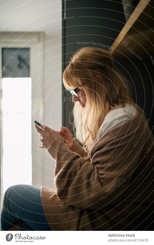 Entspannte Frau beim Surfen auf dem Smartphone Browsen sich[Akk] entspannen genießen Morgen benutzend Nachricht Abfertigungsschalter gemütlich Gelassenheit