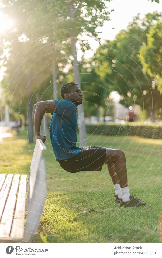 Athletischer schwarzer Mann trainiert im Park männlich Fitness Training Sport Läufer Dehnübung trainiert. Flexibilität Gesundheit Lifestyle strecken jung passen