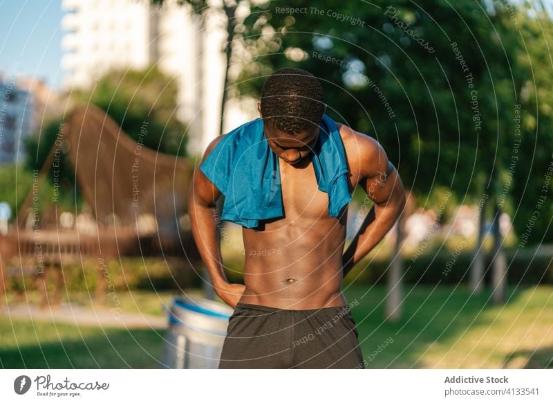 Athletischer schwarzer Mann trainiert im Park Afrikanisch ohne Hemd muskulös Fitness stark Biegung Körper passen Muskel Bizeps Stärke Lifestyle Truhe sportlich