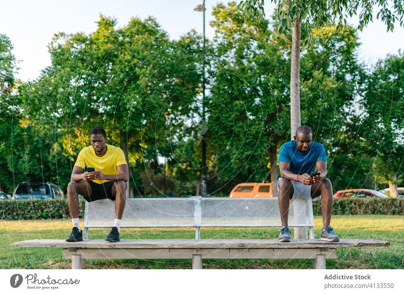 Soziale Distanzierung im Park soziale Distanzierung schwarz Männer Technik & Technologie Telefon Sitzen Selfie Lifestyle Pause Mitteilung ruhen aussruhen