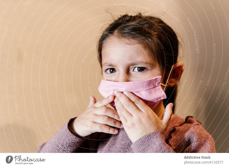 Unglückliches Mädchen mit medizinischer Maske auf der Straße während einer Coronavirus-Pandemie Mundschutz Kind Gesichtsmaske Bund 19 ethnisch unglücklich