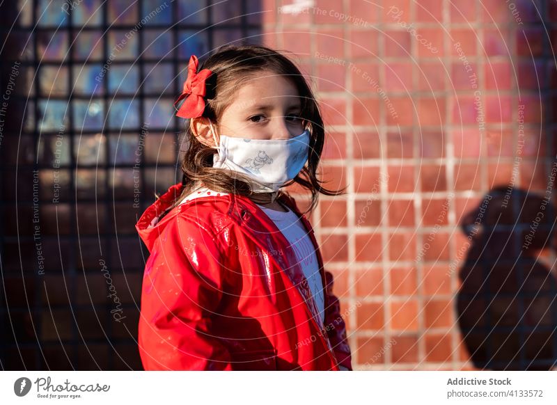 Ethnisches Mädchen mit chirurgischer Maske auf der Straße medizinisch Mundschutz Kind genießen Wochenende Bund 19 behüten ethnisch Kindheit Großstadt stehen