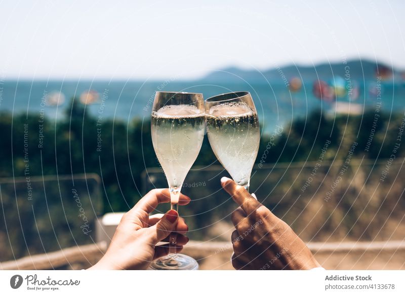 Paar stößt am Meer mit Sektgläsern an Champagne MEER Klirren Glas jubelt Sommer Zusammensein feiern genießen Seeküste Feiertag trinken Urlaub Partnerschaft