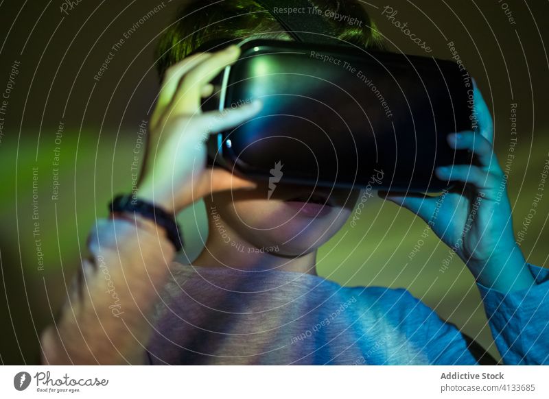 Helle Projektion auf aufgeregten Jungen im VR-Headset farbenfroh Erfahrung Kind Virtuelle Realität erkunden Technik & Technologie Simulation Gerät Apparatur