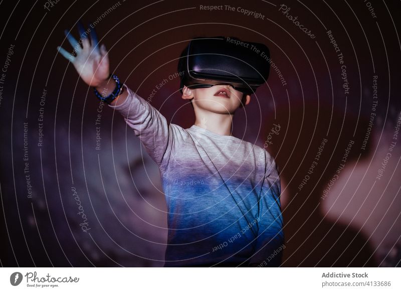 Helle Projektion auf aufgeregten Jungen im VR-Headset farbenfroh Erfahrung Kind Virtuelle Realität erkunden Technik & Technologie Simulation Gerät Apparatur