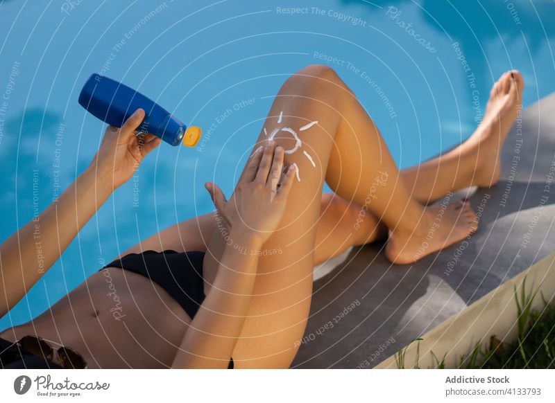 Frau trägt in der Nähe des Pools Sonnenschutz auf Sonnenbad Beckenrand bewerben Sommer Bräune Sahne Lügen Bein sich[Akk] entspannen ruhen Feiertag Erholung