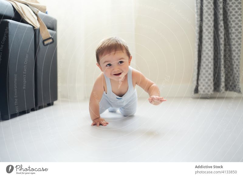 Glückliches Baby krabbelt auf dem Boden krabbeln Stock niedlich Lächeln heimwärts Kleinkind Kind Kindheit heiter Freude Lifestyle süß Entwicklung erkunden
