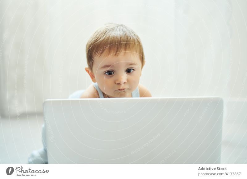 Baby spielt mit Laptop zu Hause Glück benutzend heimwärts spielen Kleinkind Apparatur modern Kindheit Lifestyle wenig allein heiter Gerät Netbook niedlich