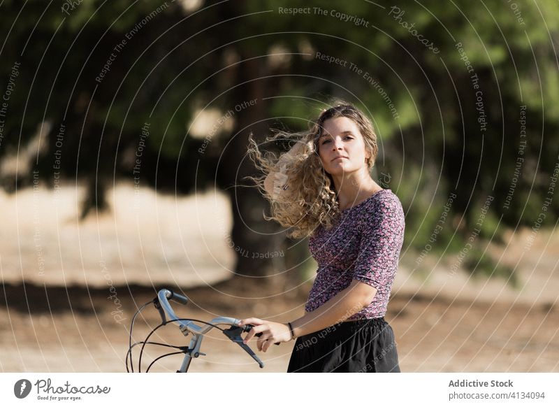 Ruhige Frau mit Fahrrad im Park Sommer Wochenende genießen Spaziergang Radfahrer Windstille sonnig ruhig Gelassenheit Outfit tagsüber ruhen grün Baum Dame