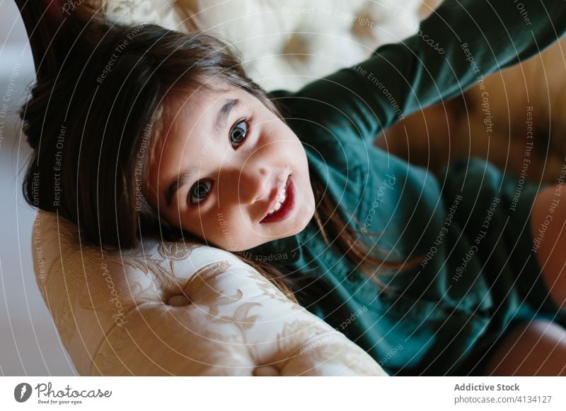 Entzückendes Mädchen entspannt auf Sofa Kind Lügen Liege gemütlich Wochenende ruhen sich[Akk] entspannen Lächeln bezaubernd Kälte Komfort heiter Freude