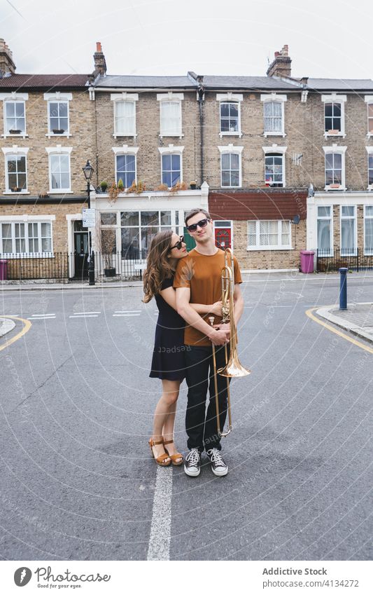 Hipster-Paar mit Posaune auf Stadtstraße Straße Stil cool Musik Instrument Zusammensein umarmt Partnerschaft Musiker London altehrwürdig England